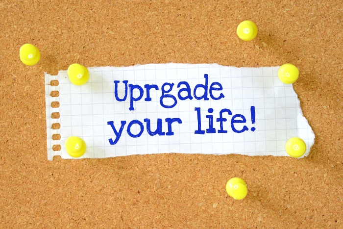 "Upgrade your life" written on piece of paper on pin board - but "upgrade" is misspelt