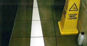 Wet Floor sign on tiled floor in retail premises