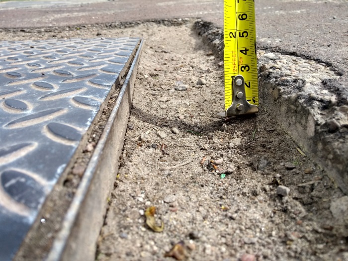 Worm's eye view of pavement defect with tape measure